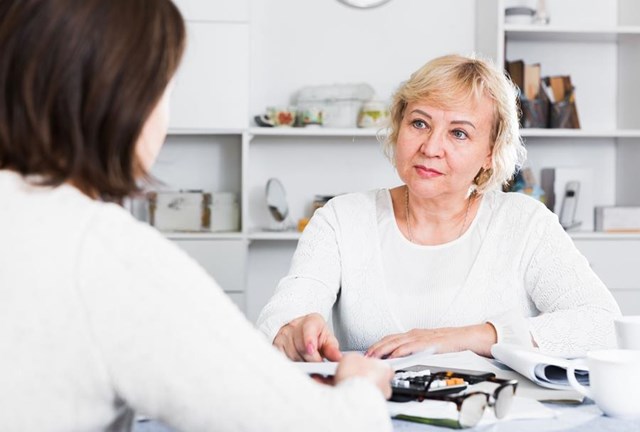 zwei Frauen sprechen miteinander an einem Tisch