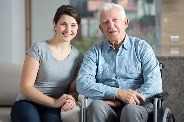 junge Frau und älterer Mann im Rollstuhl